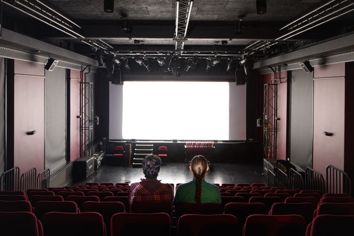 Two people look at the screen of the Imperial Cinema Club