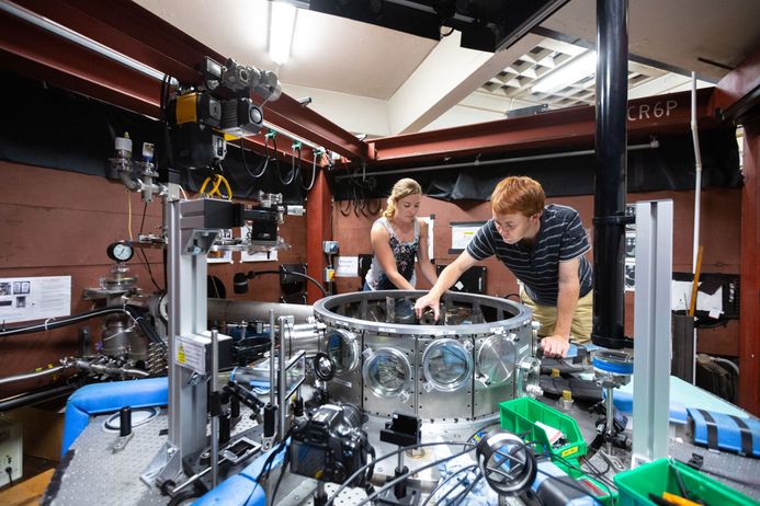 Two students adjust a pulse-powered generator in the MAGPIE Lab in the Department of Physics