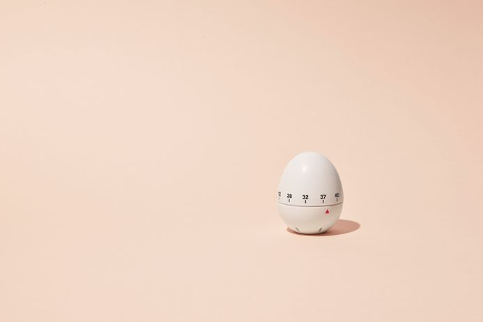 A single egg timer on a peach background