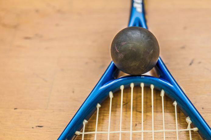 Close-up of racquet and squash ball