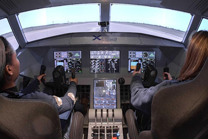 Two guests sitting in Imperials flight simulator