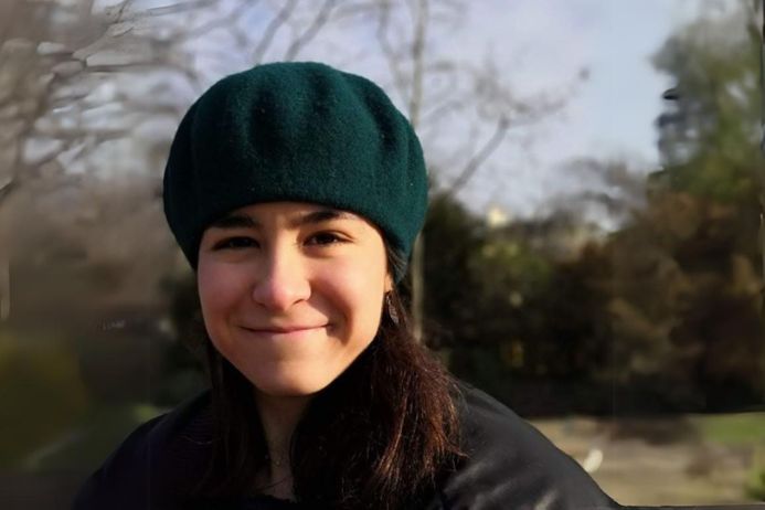 Headshot of Nieves smiling in a beret