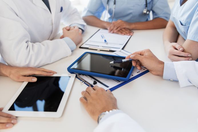 A picture of doctors looking at a digital tablet