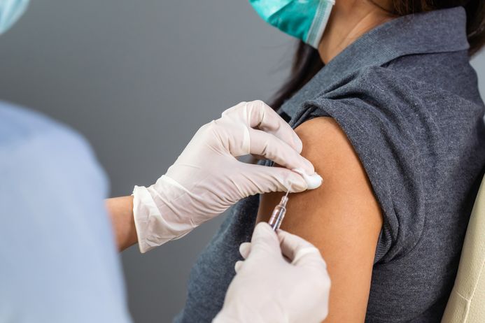 Closeup of arm being injected with a vaccine shot