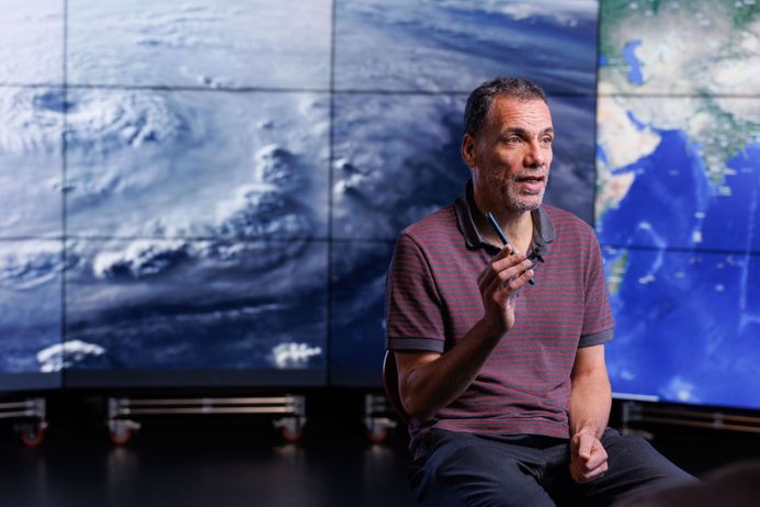 Professor Ralf Toumi in the Data Science Institute in front of a satellite view of a cyclone