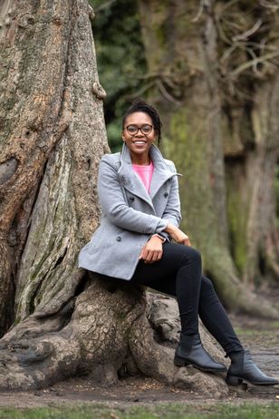 Courtnae Bailey sitting at the trunk of a tree