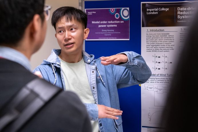 A postgraduate researcher presenting a poster