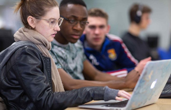 Students looking at a laptop computer