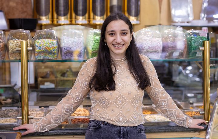 Fatima smiles by the counter at Green Valley Deli on Edgware Road