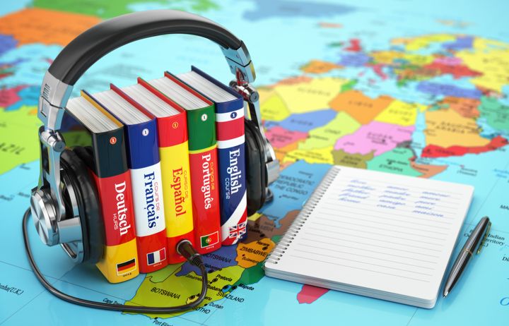 Dictionaries of various languages with a notebook and headphones