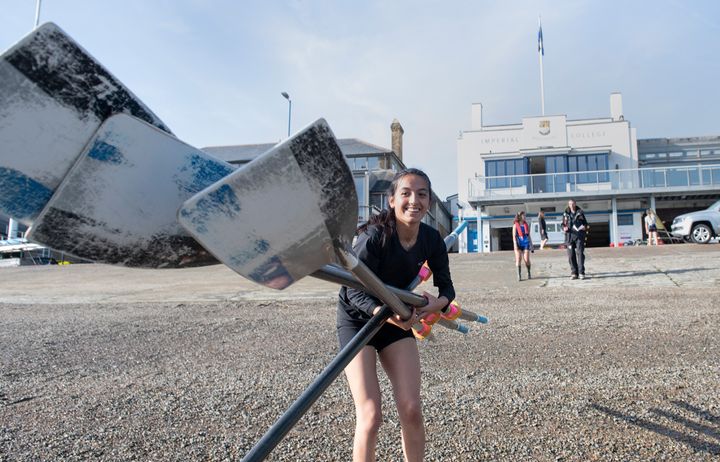 A member of the Imperial College Boat Club holding oars outside the boathouse