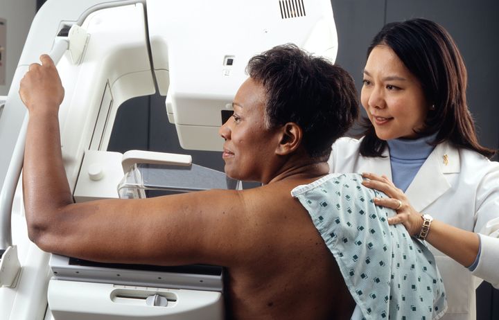 Woman have a mammogram being assisted by a female mammographer 