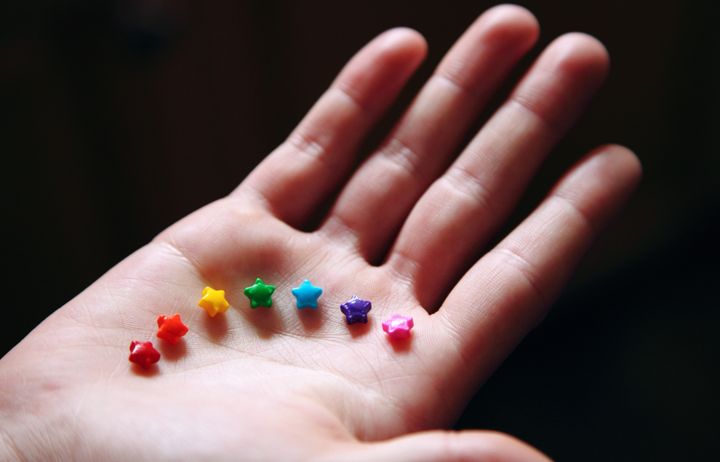 hand holding rainbow stars