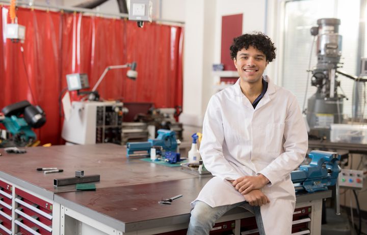 A student smiling in a workshop.