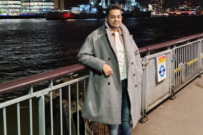 portrait of Rishant in front of the Thames at night