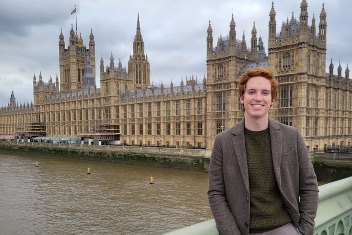 portrait of a male student in front of the houses of parliament