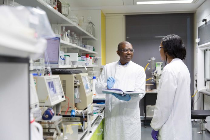 Professor Eric Aboagye talking to a postdoc in his lab