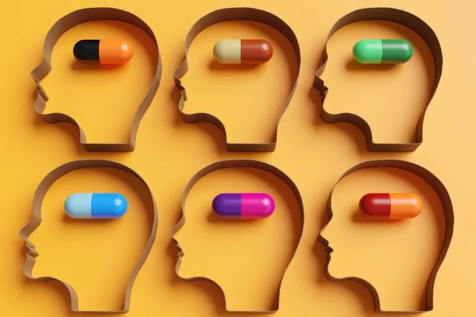 Colourful pills inside outlines of human heads