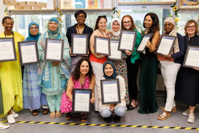 Women graduating from the Womens Community Leadership Programme stand with their certificates