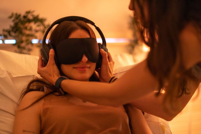 A person wearing headphones and an eye mask in a therapy session