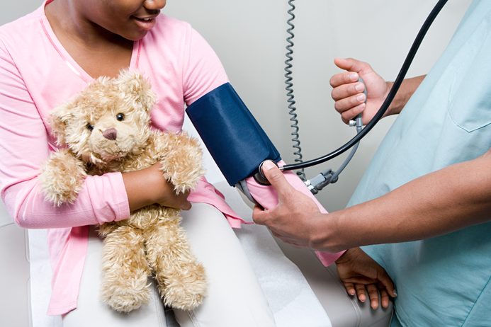 Doctor taking child blood pressure