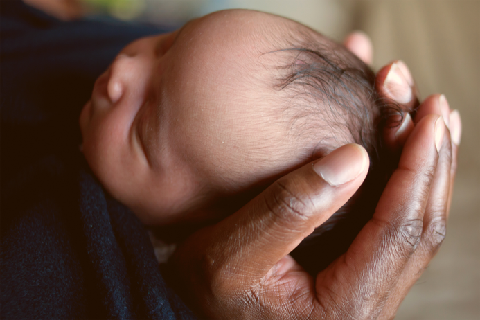 Hand holding baby's head