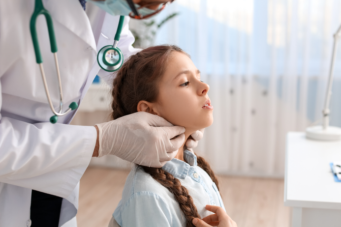 Child having her throat checked by doctor