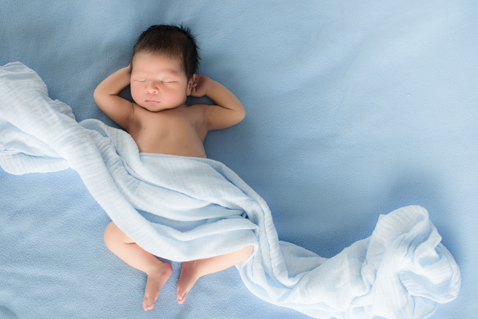 Baby sleeping in blue sheets