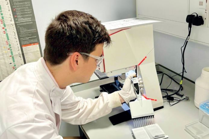 Man in lab coat pipetting