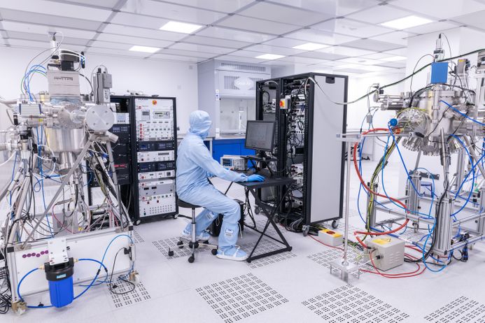 A person in a protective suit surrounded by advanced equipment