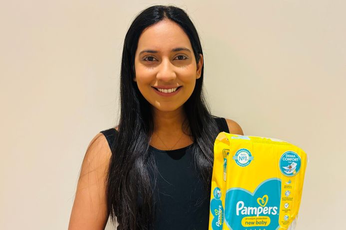 A student holding a pack of nappies