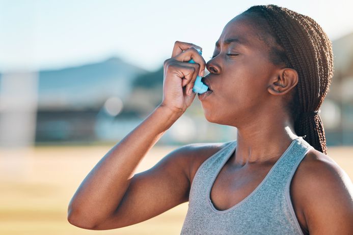 A picture of a woman using an inhaler