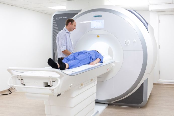 An image of an MRI Scanner with doctor and patient