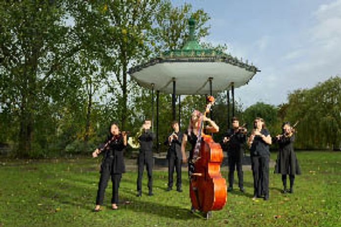 A group of musicians standing in front of a bandstand