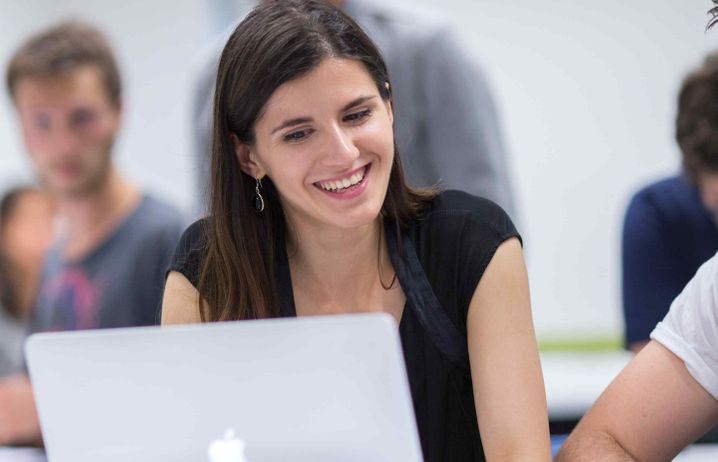 Student smiling at a laptop