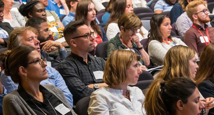 Attendees listen to a talk at a malaria meeting