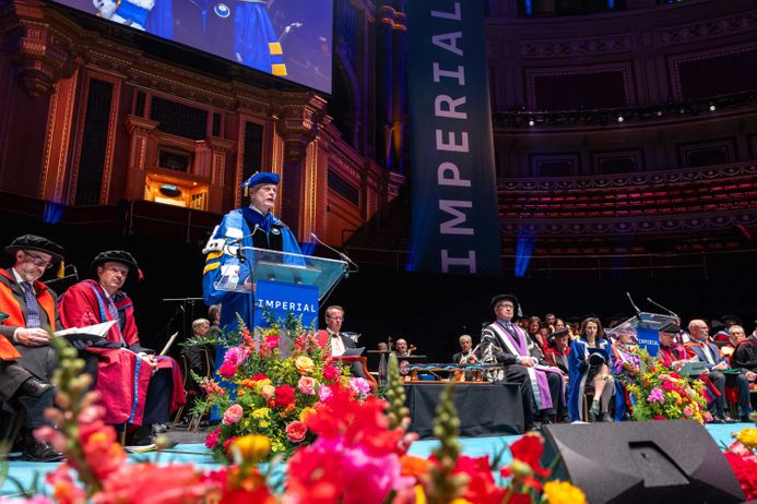 A view of the stage at Graduation Day 2024, featuring Professor Ian Walmsley and academic and professional services staff sitting on the stage.