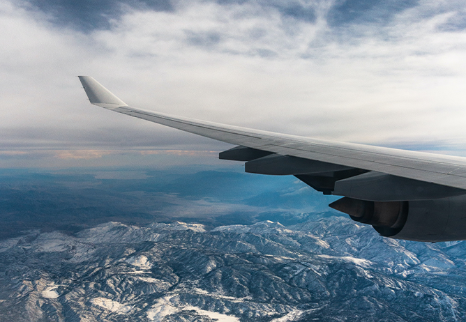 Airplane wing over a mountainscape