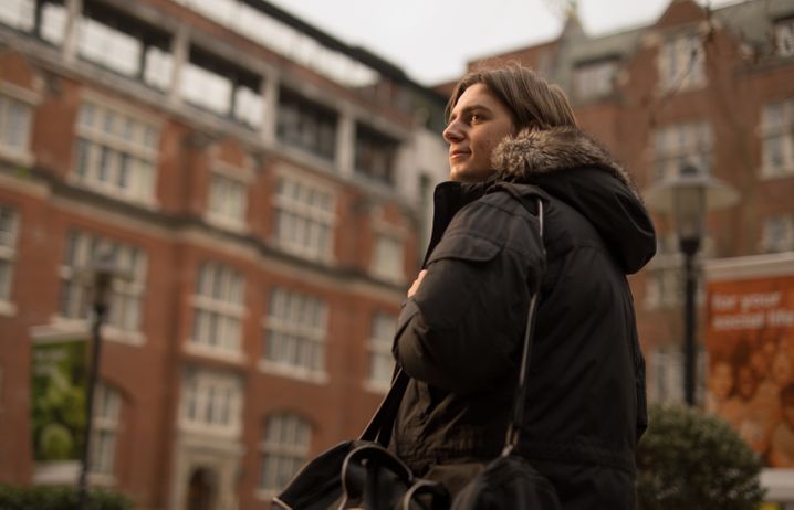 A student smiling as he walks around campus.