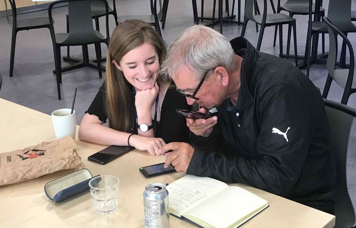 An imperial staff helping a member of the local community with her laptop