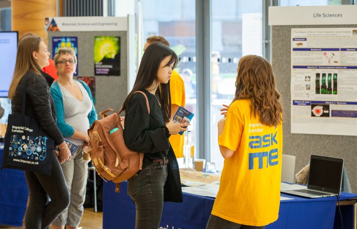 A volunteer speaks to visitors at an open day event