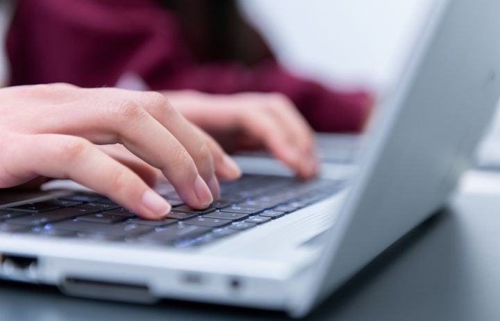 close up of hands typing on a laptop