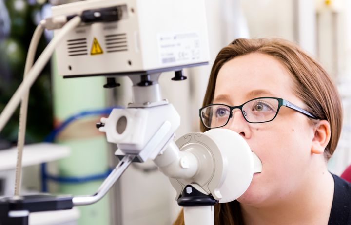 Lady blowing into respiratory device