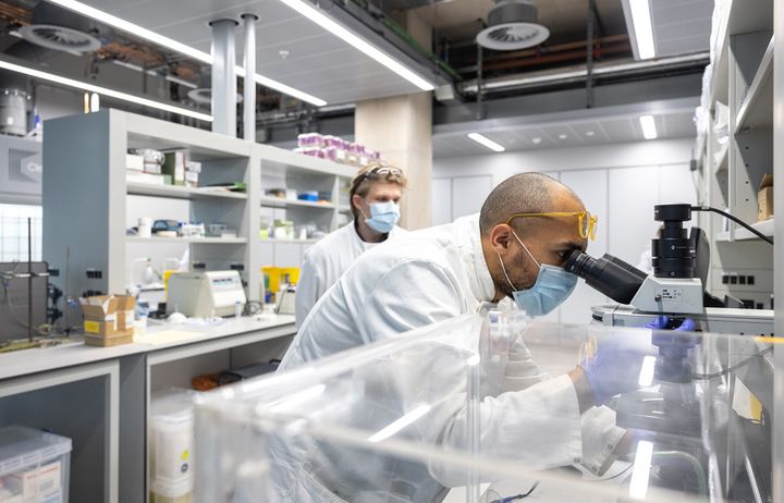 Researcher looking through a microscope