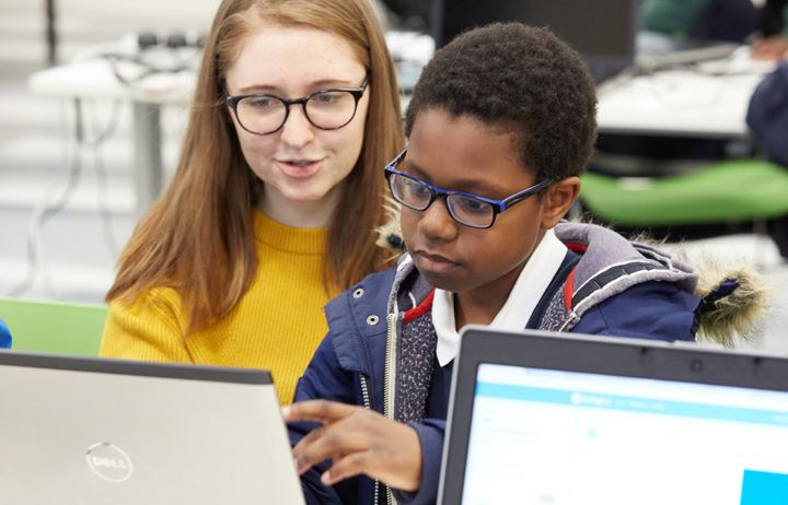 A woman and a child using a laptop as part of an outreach activity