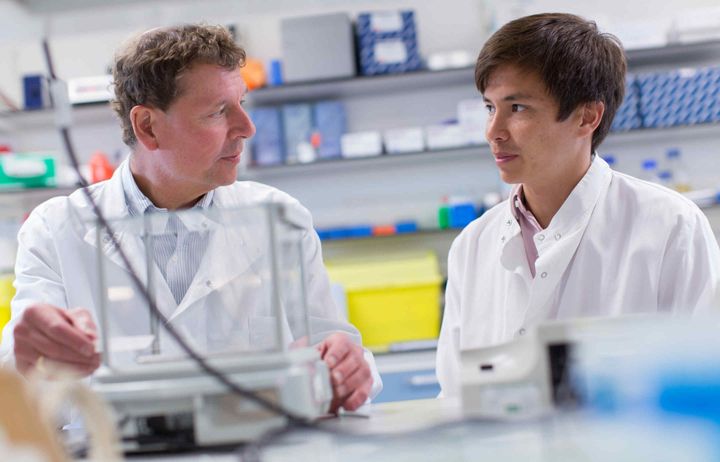 Professor Paul Matthews working with a PhD student in the lab