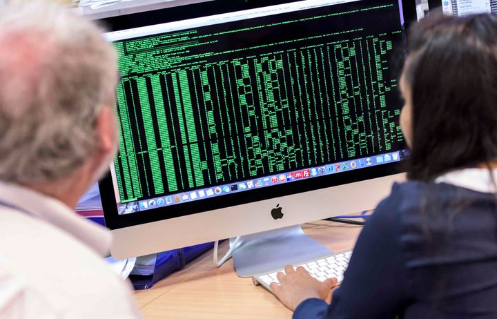 Students and supervisor look at results on computer