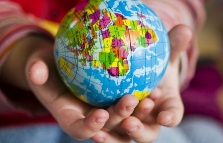 A child holding a model of the globe