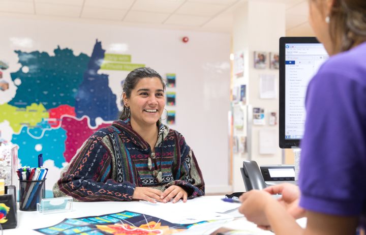 A photograph of a student speaking to one of the College's Student Hub advisors