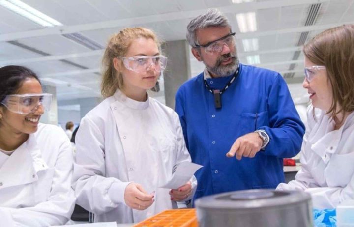 Young women scientists in a lab with a supervisor